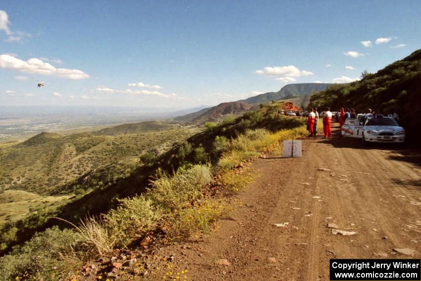 A helicopter carrying ESPN2 cameraman Doug Plumer passes the cars and drivers awaiting the stage start.