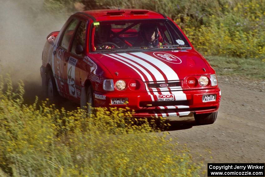 The Mike Whitman / Paula Gibeault Ford Sierra Cosworth at speed near the start of SS1.