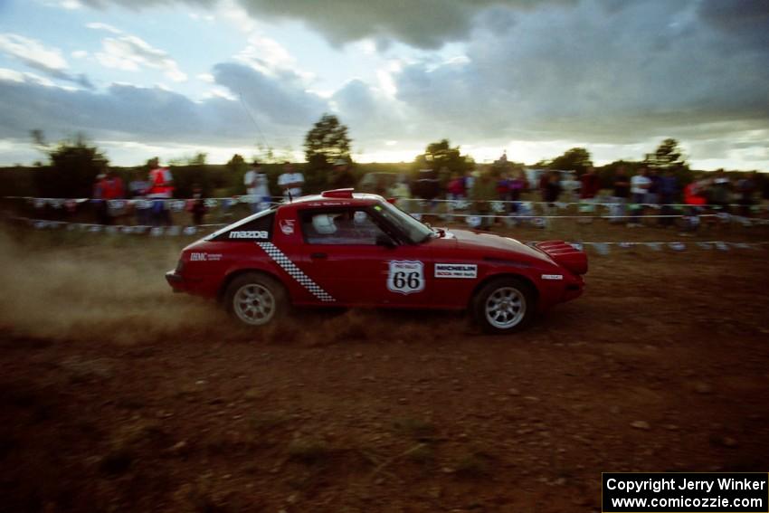 The Doug Robinson / Chrissie Beavis Mazda RX-7 comes through the spectator point just before sundown.