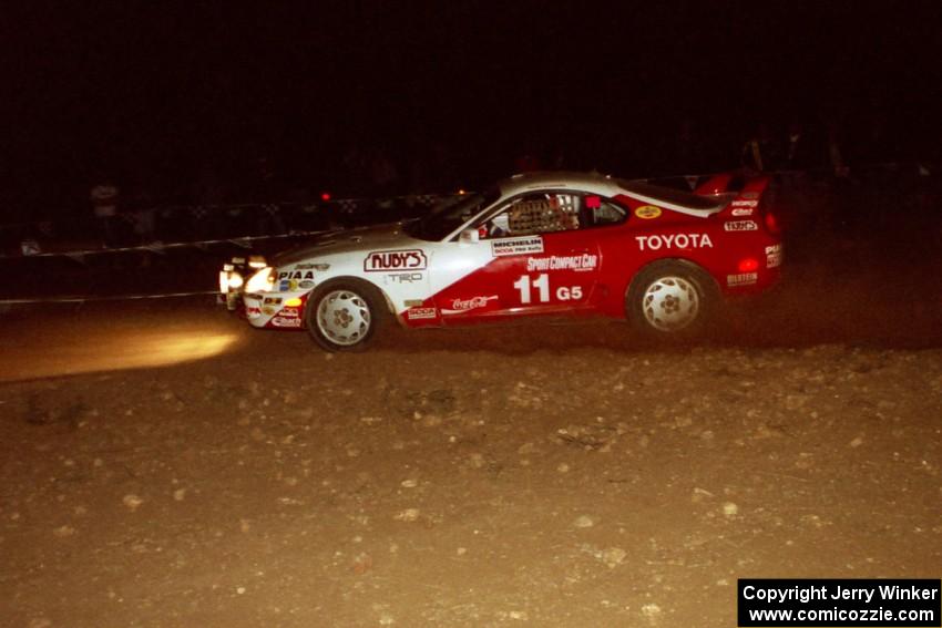 The Ralph Kosmides / Joe Noyes Toyota Supra Turbo comes through the spectator point at night.