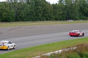 Ricky Sanders' Chevy Monte Carlo and Tim Gray's Porsche GT3 Cup head through turn 1
