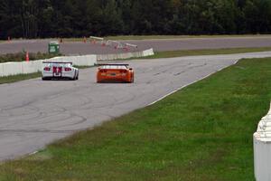 Denny Lamers' Ford Mustang and Doug Harrington's Chevy Corvette go side-by-side headed into turn one