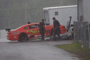 Tom Sheehan's Chevy Camaro is loaded onto the trailer during the rainy MX-5 Cup race and is a DNS