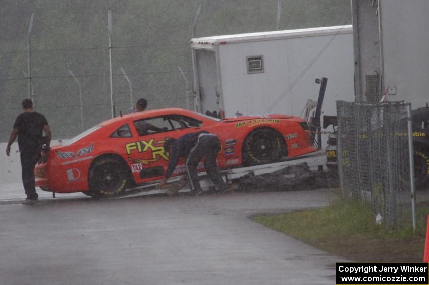 Tom Sheehan's Chevy Camaro is loaded onto the trailer during the rainy MX-5 Cup race and is a DNS