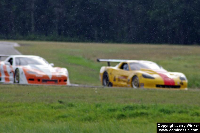 Tony Ave's Chevy Corvette passes Simon Gregg's Chevy Corvette as the rain starts to fall
