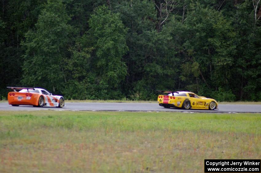 Tony Ave's Chevy Corvette passes Simon Gregg's Chevy Corvette as the rain starts to fall