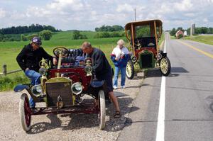 Rob Heyen's 1906 Ford stops for minor repairs and is helped by Dave Dunlavy in his 1905 Ford