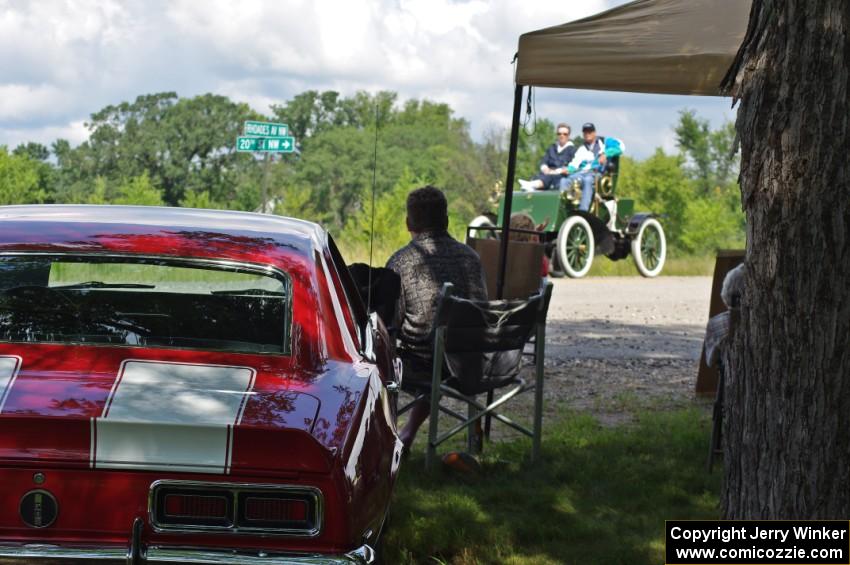 An owner of a Chevy Camaro SS watches as John Bohmer's 1903 Knox passes by