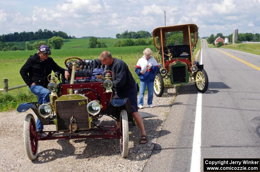 Rob Heyen's 1906 Ford stops for minor repairs and is helped by Dave Dunlavy in his 1905 Ford