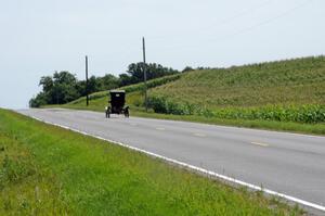 An unknown antique car putters across the Minnesota farmland