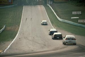 Four cars head out of turn 5 uphill toward 6