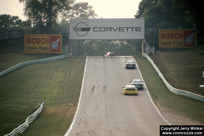 Four cars head out of turn 5 uphill toward 6