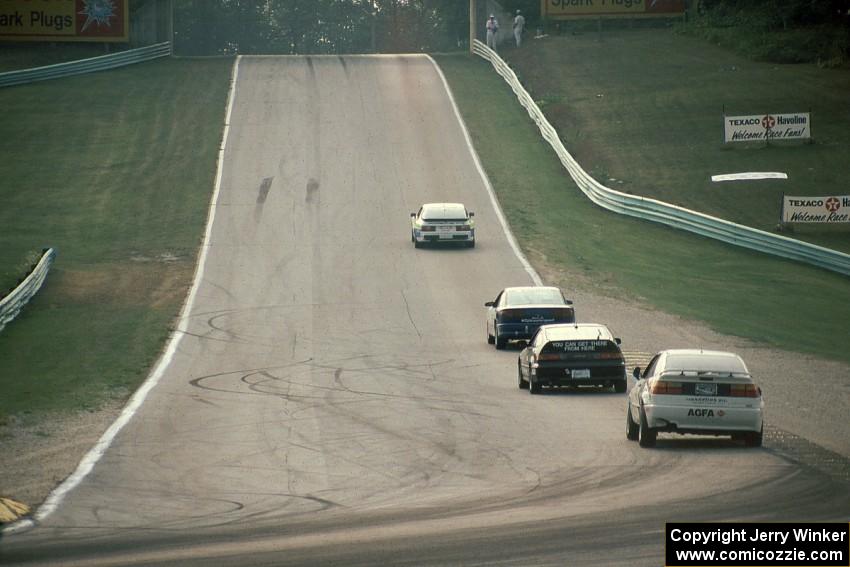 Four cars head out of turn 5 uphill toward 6