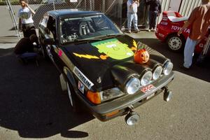 Tom Ottey / Pam McGarvey Mazda 323GTX at parc expose outside Dee Stadium.