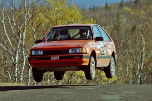 Gail Truess / Pattie Hughes Mazda 323GTX catches air on SS13, Brockway I.