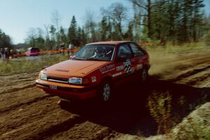 Gail Truess / Pattie Hughes Mazda 323GTX at speed through the spectator corner of SS15, Gratiot Lake II.