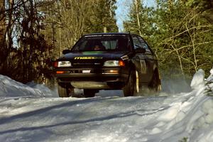 Tom Ottey / Pam McGarvey Mazda 323GTX come over a crest at speed just before sundown.