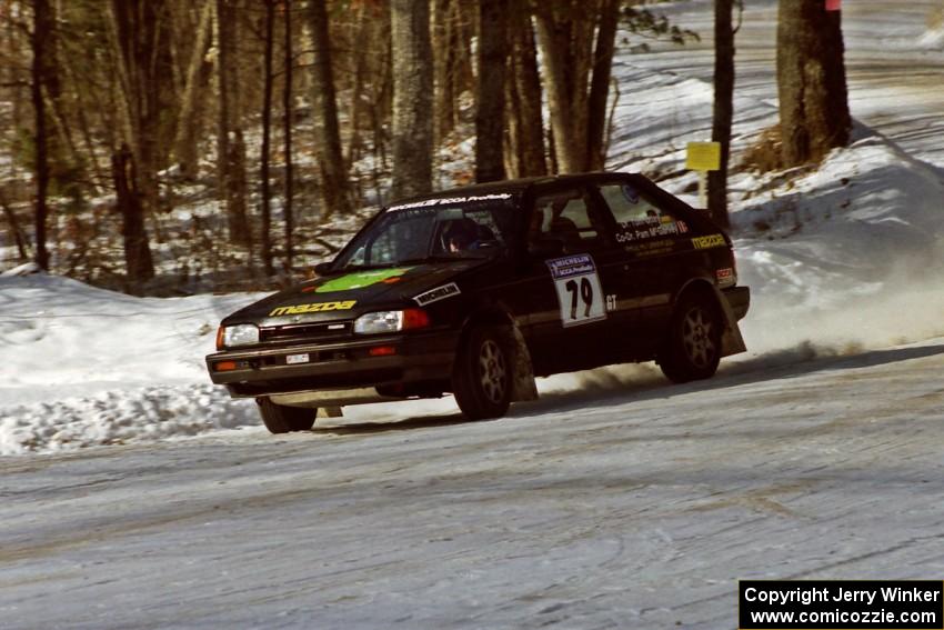 Tom Ottey / Pam McGarvey Mazda 323GTX sets up for a 90-left at the SS1 spectator corner.