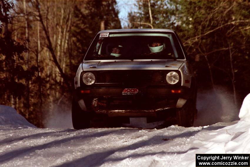 Wayne Prochaska / Annette Prochaska at speed over a crest before sundown in their VW Golf.