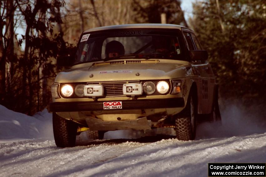 Tim Winker / Brenda Corneliusen come over a crest at speed in their SAAB 99 before sundown.