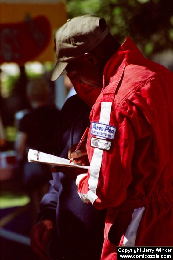 Arthur Odero-Jowi signs an autograph at the green in Wellsboro before the rally.