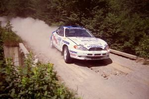 Noel Lawler / Charles Bradley Hyundai Tiburon at speed over a bridge on SS5, Magalloway North.