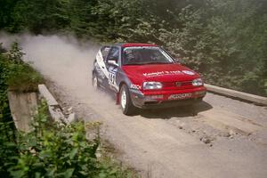 Jon Nichols / Mike Koch VW Golf at speed over a bridge on SS5, Magalloway North.