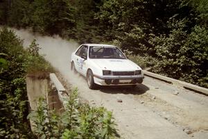 Henry Krolikowski / Cindy Krolikowski Dodge Shadow at speed over a bridge on SS5, Magalloway North.