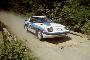 Mike Hurst / Rob Bohn Mazda RX-7 at speed over a bridge on SS5, Magalloway North.