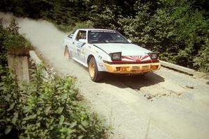 Mark Bowers / Duffy Bowers Mitsubishi Starion at speed over a bridge on SS5, Magalloway North.