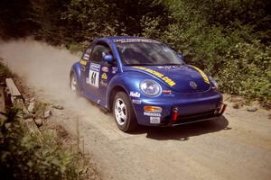 Karl Scheible / Gail McGuire VW Beetle at speed over a bridge on SS5, Magalloway North.