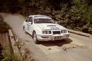 Colin McCleery / Jeff Secor Merkur XR4Ti at speed over a bridge on SS5, Magalloway North.