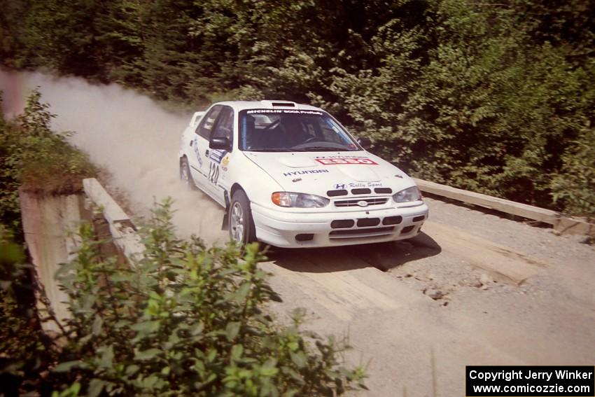 Dean Panton / Michael Fennell Hyundai Elantra at speed over a bridge on SS5, Magalloway North.