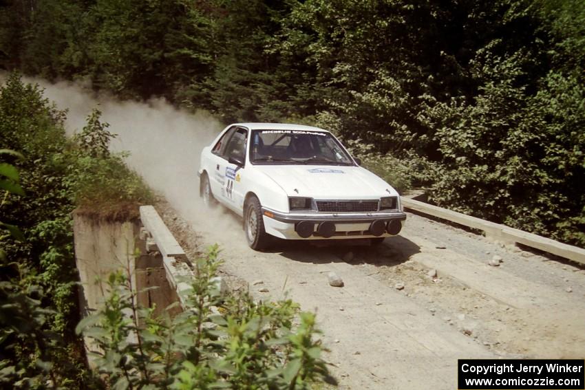 Henry Krolikowski / Cindy Krolikowski Dodge Shadow at speed over a bridge on SS5, Magalloway North.