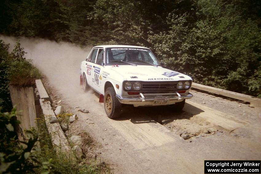 Walt Kammer / Jackie Adams Datsun 510 at speed over a bridge on SS5, Magalloway North.