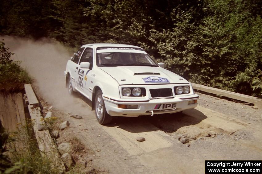 Colin McCleery / Jeff Secor Merkur XR4Ti at speed over a bridge on SS5, Magalloway North.
