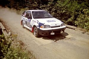 Ilana Rosenshein / Jennifer Cote Suzuki Swift GTi at speed over a bridge on SS5, Magalloway North.