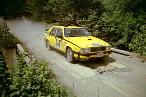 Fred Carpenter / Josh Bressem Alfa Romeo Milano at speed over a bridge on SS5, Magalloway North.