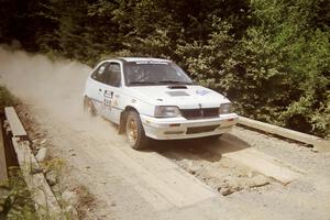 Matt Lewis / Tony Lumino Pontiac LeMans at speed over a bridge on SS5, Magalloway North.