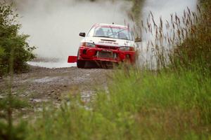 Garen Shrader / Doc Schrader Mitsubishi Lancer Evo IV splashes through a puddle on SS8, Parmachenee Long.