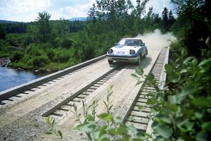 Mike Hurst / Rob Bohn Mazda RX-7 at speed over a bridge on SS8, Parmachenee Long.
