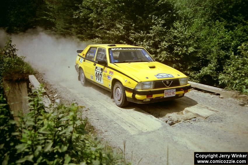 Fred Carpenter / Josh Bressem Alfa Romeo Milano at speed over a bridge on SS5, Magalloway North.