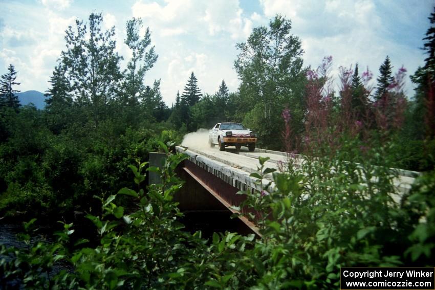 Mark Bowers / Duffy Bowers Mitsubishi Starion at speed over a bridge on SS8, Parmachenee Long.