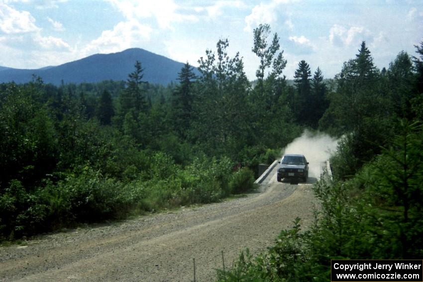 Tom Lawless / Brendan Lawless VW GTI at speed over a bridge on SS8, Parmachenee Long.