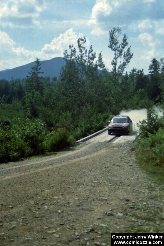 Evan Moen / Tom Young  Plymouth Neon ACR at speed over a bridge on SS8, Parmachenee Long.