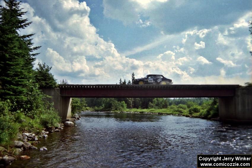 Mike White / Mike Ronan SAAB 99GLI at speed over a bridge on SS8, Parmachenee Long.