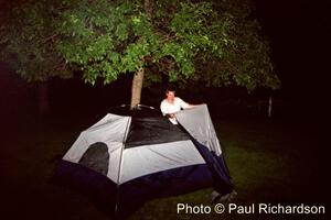 Jerry Winker tries to assemble his tent in the wee hours of the morning.
