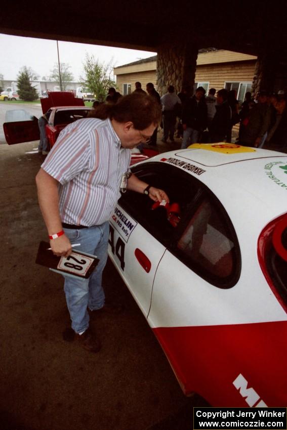 Dave Sutliff checks belts on the Miroslaw Babinski / Piotr Modzejewski Toyota Celica All-trac.