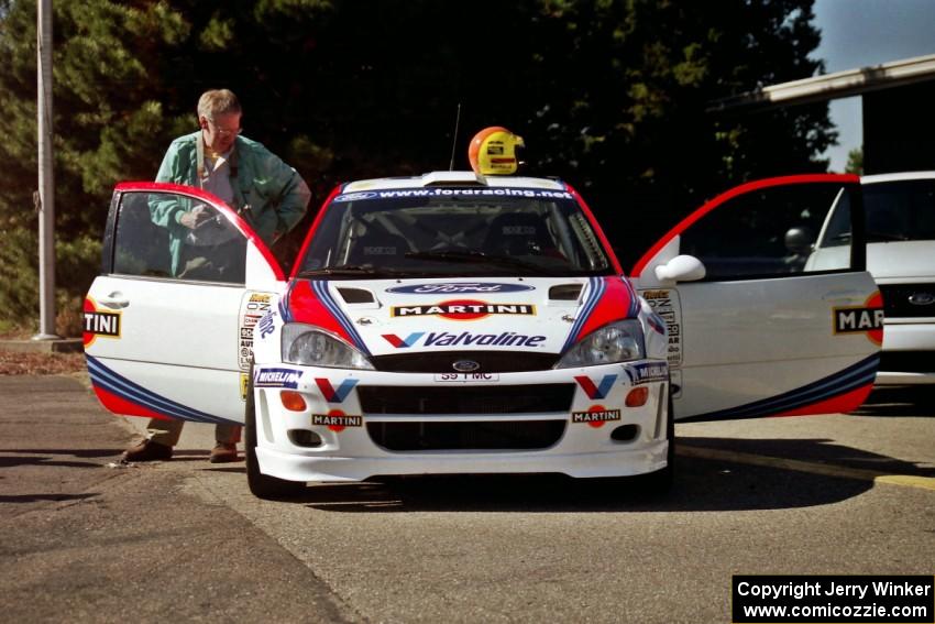 A member of the press views the interior of the Ford Focus WRC.