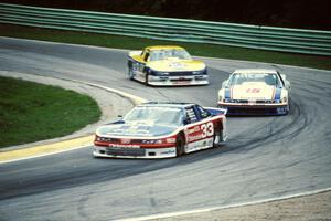 Scott Sharp's Olds Cutlass Supreme, Irv Hoerr's Olds Cutlass Supreme and Chris Kneifel's Chevy Beretta on lap one